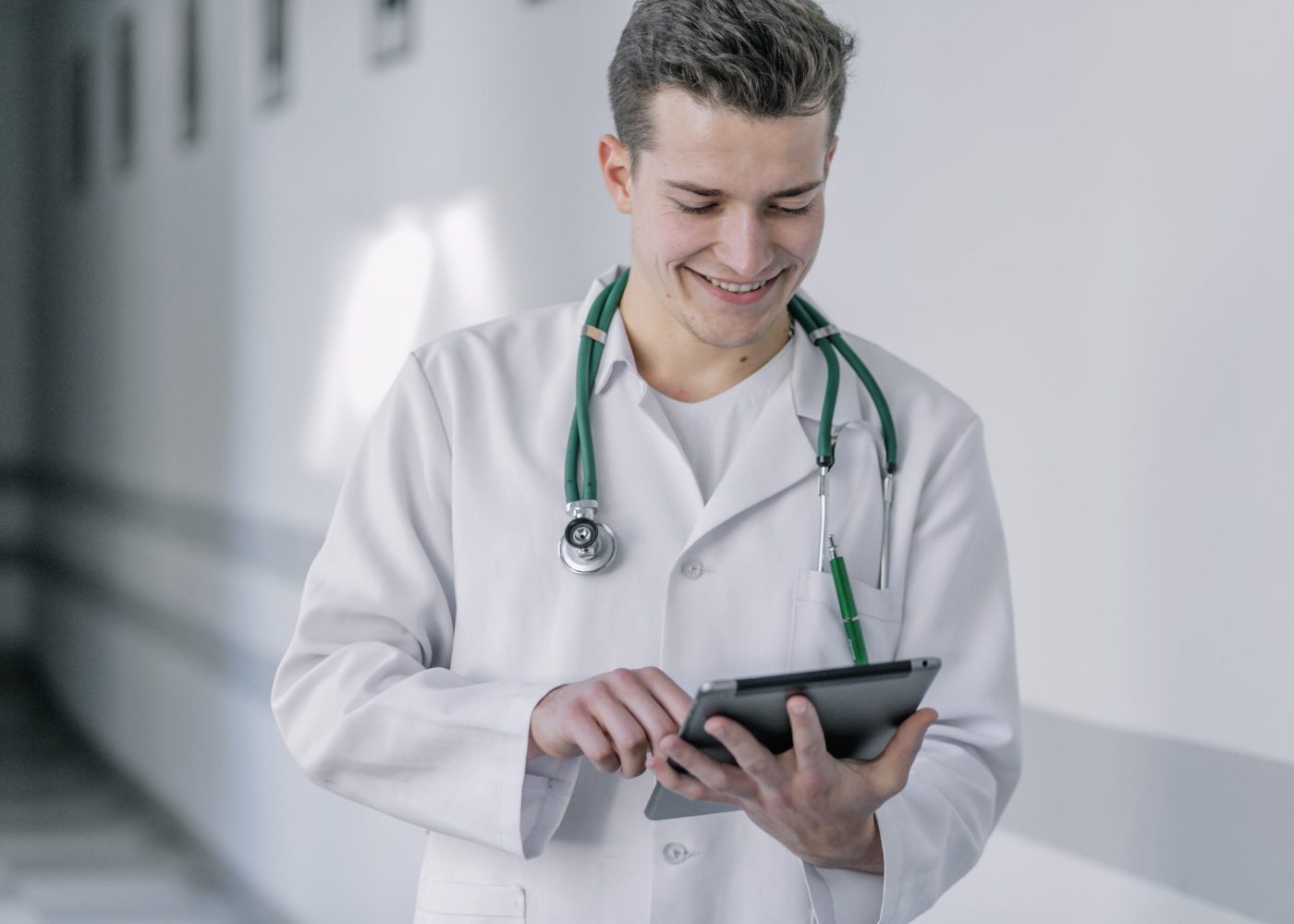 cheerful-young-doctor-using-tablet-min